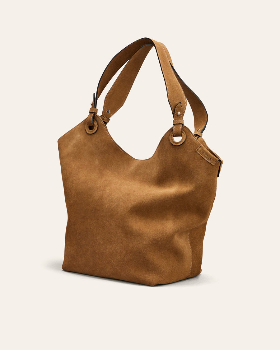 Brown suede leather handbag on a light beige background